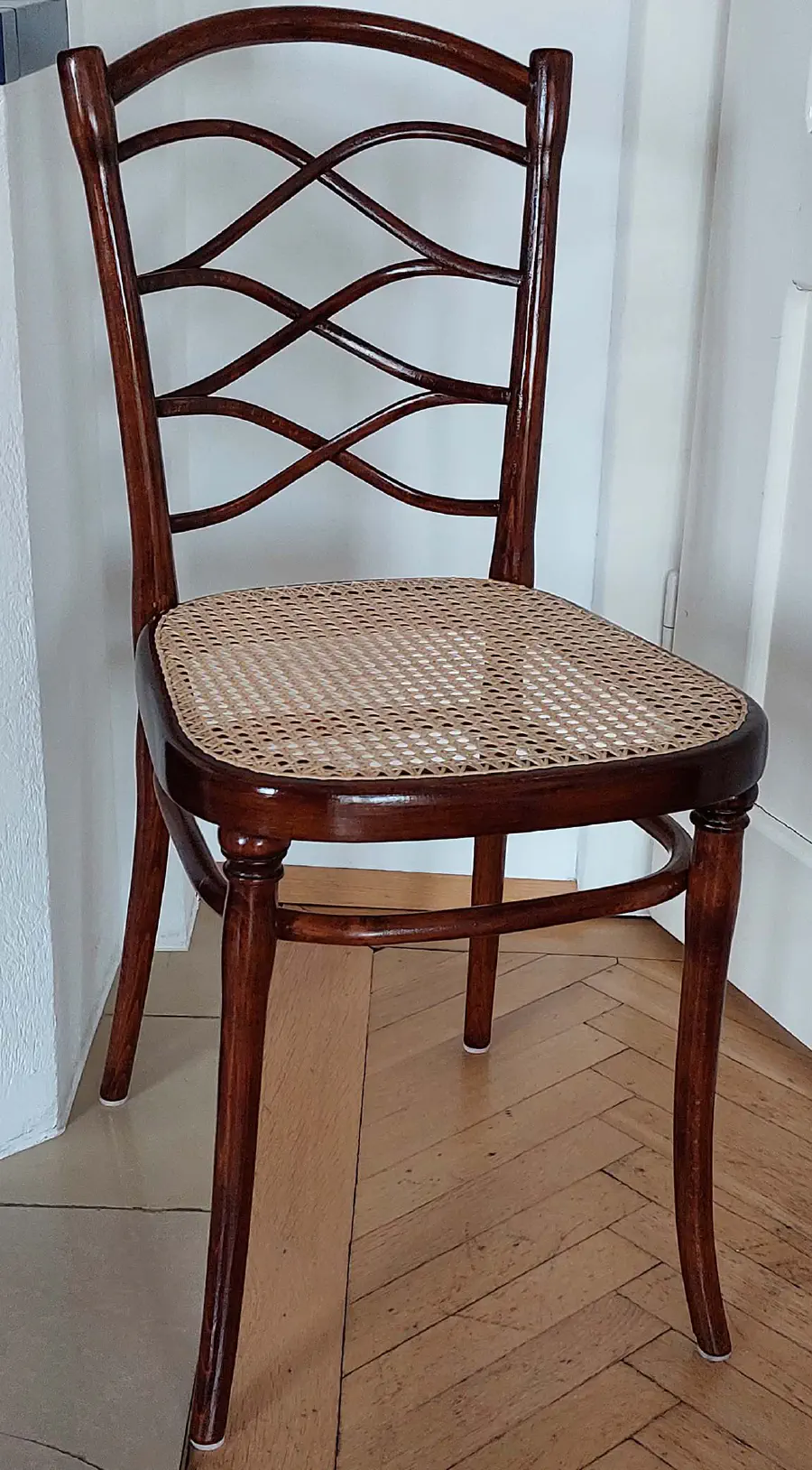 Stuhl mit geschwungener Rückenlehne und neu geflochtener Sitzfläche