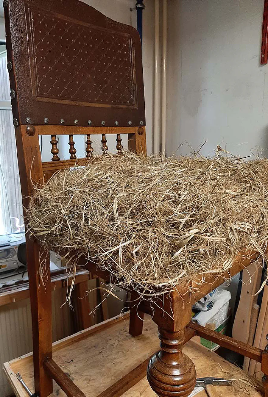 Stuhl während der Polsterarbeiten mit traditioneller Naturfaser-Füllung